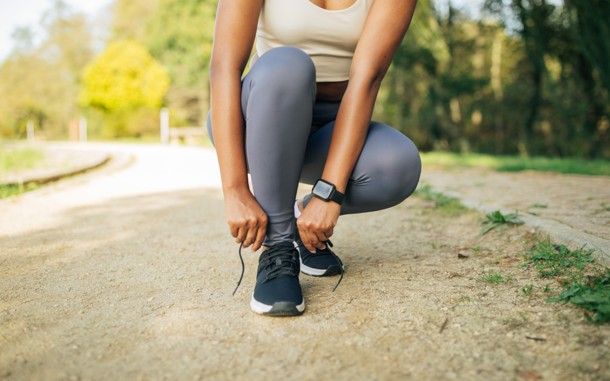 woman lacing up sneaker