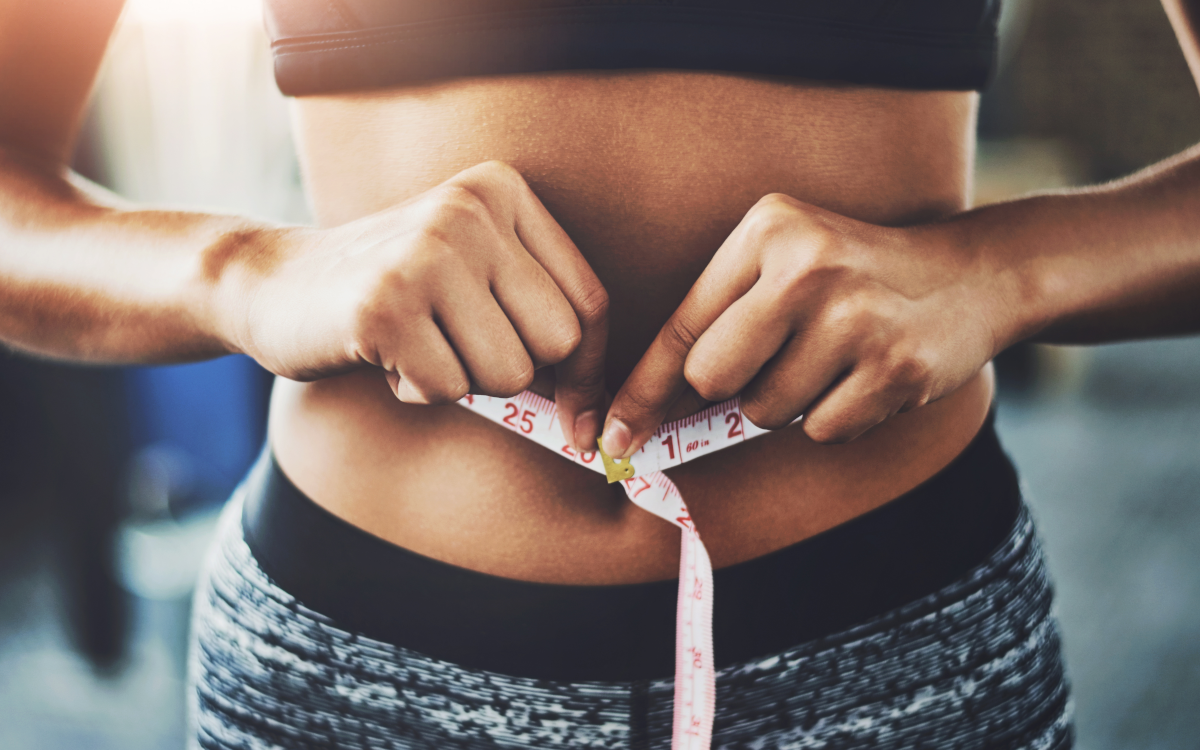 woman measuring her waist